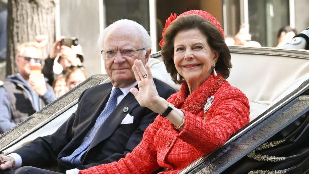 König Carl XVI. Gustaf und Königin Silvia von Schweden winken in einer Kutsche der Öffentlichkeit zu.