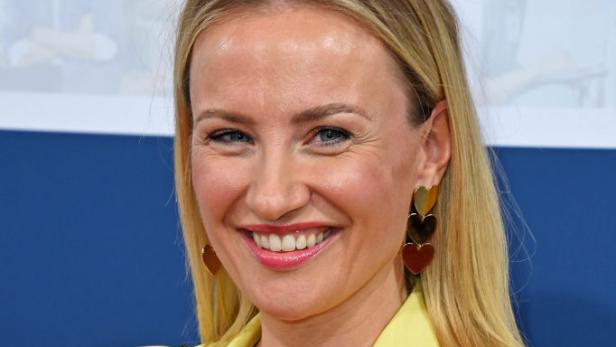 Ania Niedieck lächelt in einem gelben Blazer bei einer öffentlichen Veranstaltung.