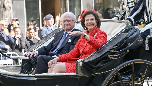 König Carl XVI. Gustaf und Königin Silvia von Schweden fahren in einer Kutsche an Schaulustigen vorbei.