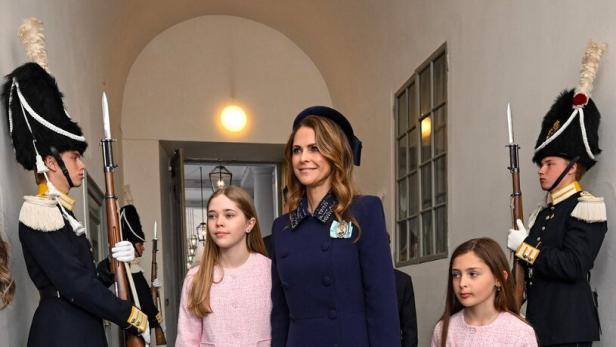 Prinzessin Madeleine von Schweden geht mit ihren Töchtern Leonore und Adrienne an zwei Wachen in Uniform vorbei.