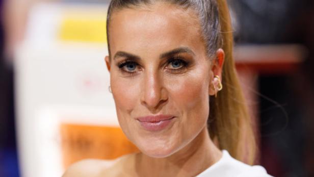 Charlotte Engelhardt posiert in weißem One-Shoulder-Kleid bei einem Event.