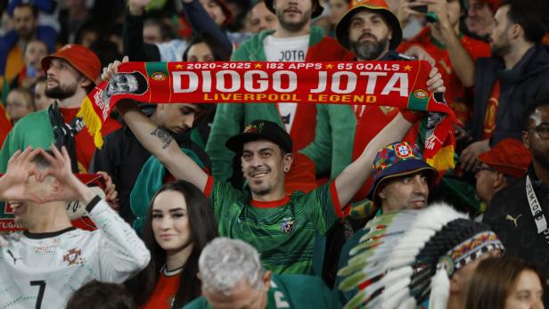 Fan hat einen roten Schal mit der Aufschrift "Diogo Jota" in der Hand