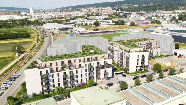 Luftaufnahme eines Stadtviertels mit geplanten Wohnhäusern, Straßen und Hügeln im Hintergrund.