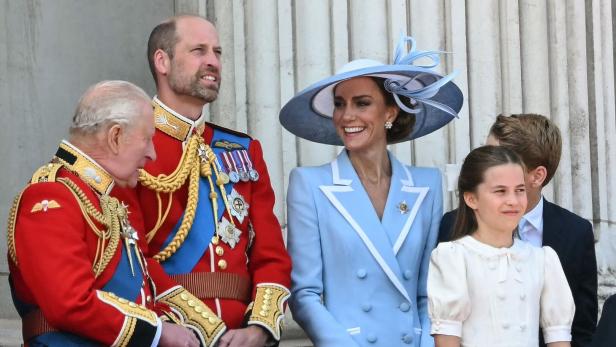 König Charles III., Prinz William, Prinzessin Kate und Prinzessin Charlotte stehen gemeinsam auf einem Balkon.