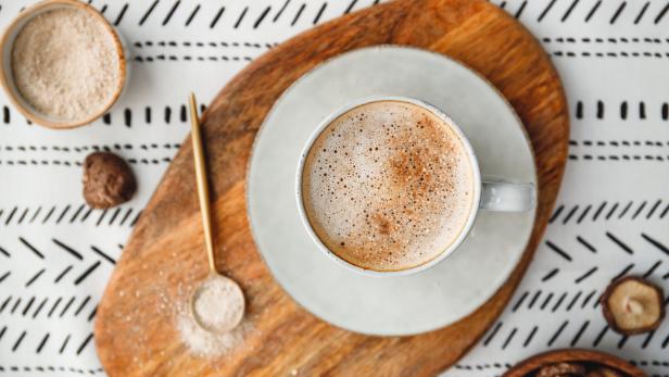 Top view of mushroom latte with Shiitake powder and unsweetened coconut-almond blend milk. Healthy useful vegan drink, flat lay.