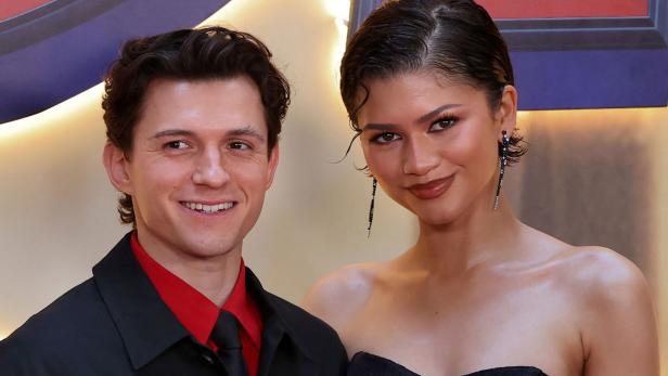 Tom Holland und Zendaya lächeln gemeinsam in die Kamera.