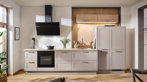 Moderne Küche in Beige und Holz mit matten Fronten und schwarzer Dunstabzugshaube.