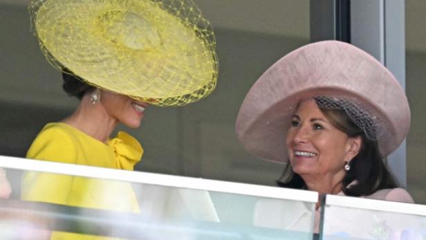 Catherine, Prinzessin von Wales, und ihre Mutter Carole Middleton unterhalten sich lächelnd auf einem Balkon mit Blumen.