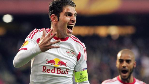 Ein Fußballspieler im Trikot von Red Bull jubelt auf dem Spielfeld.