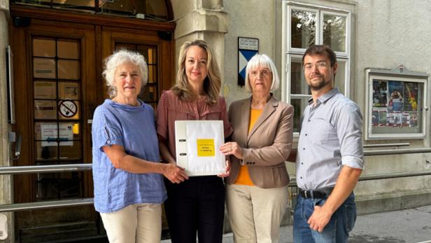 Drei Frauen und ein Mann vor einem Gebäude