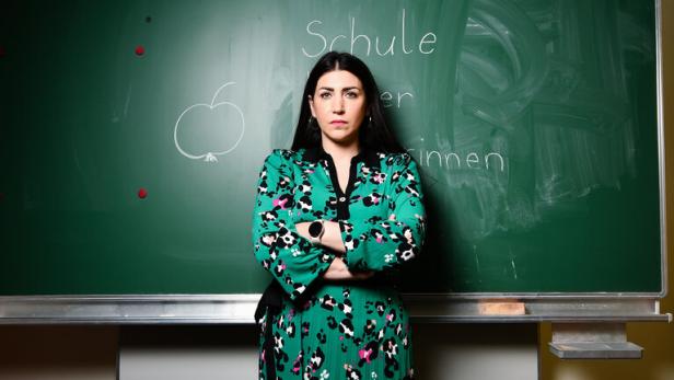 Die Wiener Volksschullehrerin Ilkay Idiskut steht vor einer grünen Schultafe 