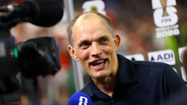 Thomas Tuchel spricht in ein Mikrofon mit dem Logo der FIFA World Cup 2026.