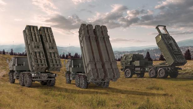 3 Raketenartillerie-Fahrzeue des Typs HIMARS stehen in einer Graslandschaft
