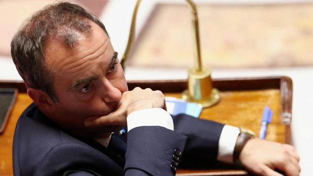 Sebastien Lecornu sitzt nachdenklich mit der Hand am Kinn an einem hölzernen Pult.
