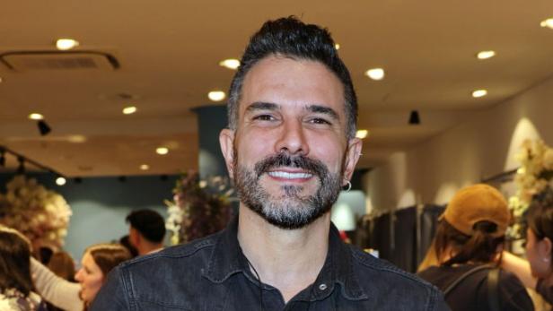 Marc Terenzi lächelt bei einem Auftritt in dunklem Hemd mit sichtbaren Arm-Tattoos.
