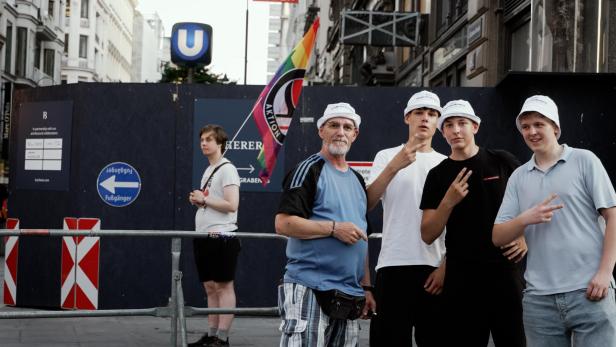 FPÖ-Unterstützer und ein Mann mit Regenbogen-Antifa-Fahne beim FPÖ-Volksfest am Stephansplatz
