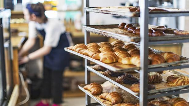 Fresh French Bread and croissants in a Bakery in cooling rack