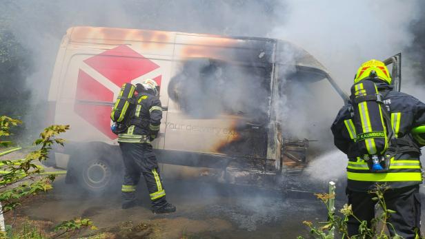 Zwei Feuerwehrmänner löschen den Pkw.