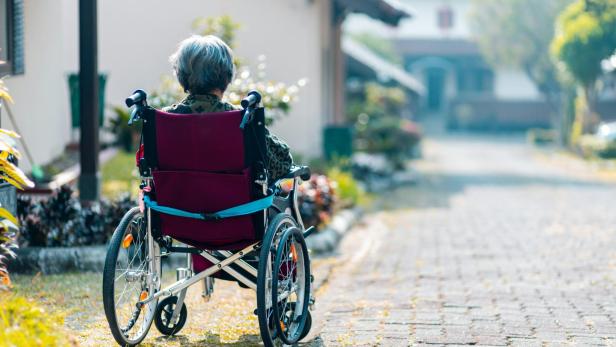 Frau in Rollstuhl von hinten