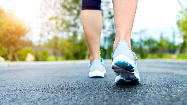 Woman's running shoes on asphalt road