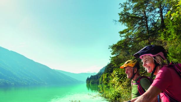 Radfahrer genießen die Sommeridylle am Weissensee.