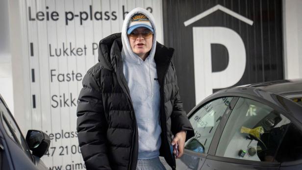 Marius Borg Høiby mit Kapuzenpullover, schwarzer Daunenjacke, Sonnenbrille und Stetson-Cap steht vor einem Parkhaus.