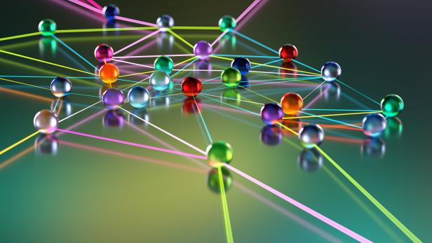 Bunte, glänzende Kugeln sind durch ein Netz aus leuchtenden, farbigen Linien auf einer reflektierenden Oberfläche miteinander verbunden.