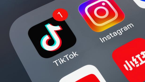 Smartphone-Startbildschirm mit TikTok-, Instagram- und weiteren App-Icons, TikTok mit roter Benachrichtigung „1“.