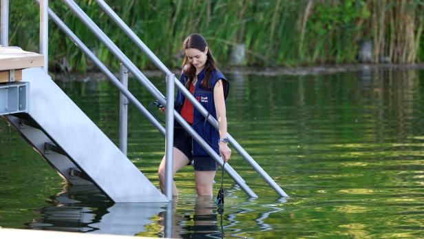 Eine Mikrobiologin misst die Wassertemperatur.