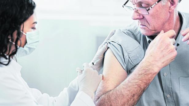 Closeup portrait nurse doing injection to senior man