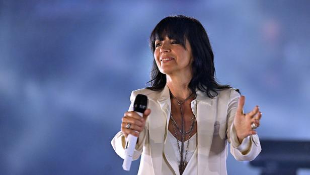 Nena performt in einem weißen Anzug auf der Bühne.