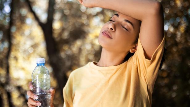 Young woman drinking water taking a break