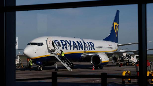 Ein Flugzeug der Fluggesellschaft Ryanair steht auf dem Rollfeld, während Bodenpersonal die Passagiertreppe nutzt.