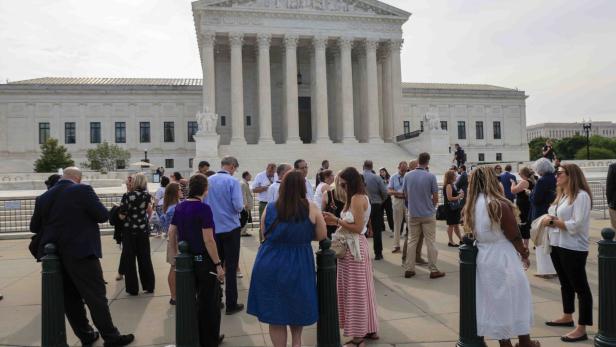 Menschen stehen vor dem Gebäude des Obersten Gerichtshofs der Vereinigten Staaten in Washington, D.C.