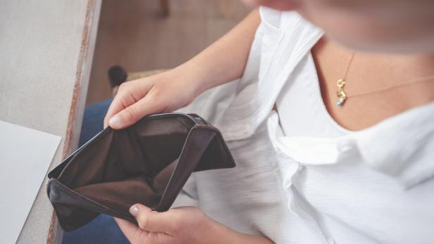 Woman opening an empty wallet.