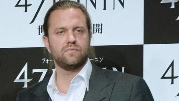 Mann im Anzug vor einer 47-Ronin-Pressewand.