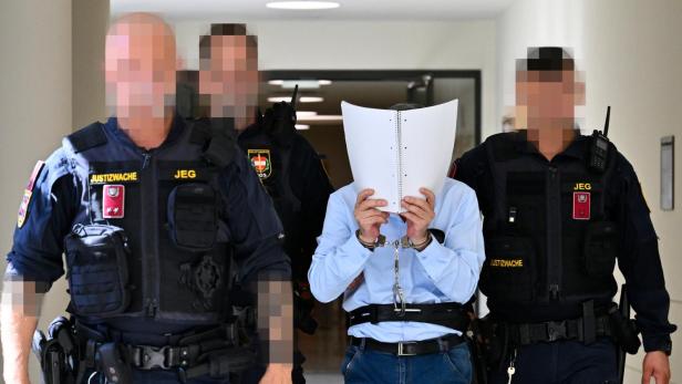 Khaled H. wird von Justizwachebeamten zur Verhandlung geführt. 