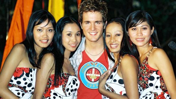 Ein Mann posiert mit vier Frauen für ein Foto.