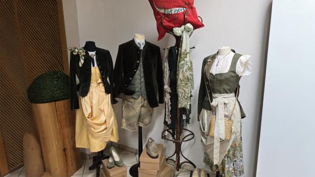 Schaufensterpuppen mit Dirndl, Trachtenjanker und Lederhose in einem Trachtengeschäft.
