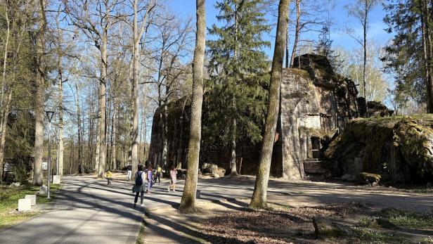 Besucher spazieren an den  Betonruinen der Wolfsschanze in Gierłoż vorbei.