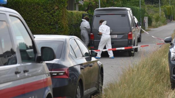 Polizei und Spurensicherung arbeiten an einem abgesperrten Wohnhaus.
