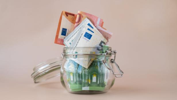 Euro cash banknote in glass jar on beige background. Saving money concept crisis and inflation Consumption and economy Collecting money. Tips. Extra money, passive