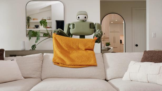 Roboter glättet ein Kissen auf einem Sofa.