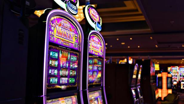 Leuchtende Spielautomaten in einem Casino am Flughafen.