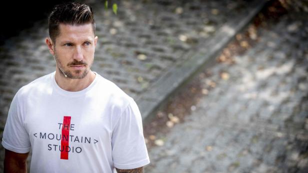 Marcel Hirscher steht draußen vor unscharfem Hintergrund und blickt nach links.