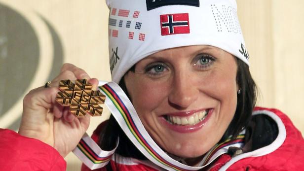 Marit Bjoergen of Norway poses on the podium with her gold medal during the medal ceremony for the women&#039;s skiathlon competition at the Nordic Ski World Championships in the northern mountain resort of Cavalese in Val di Fiemme February 23, 2013. REUTERS/Yves Herman (ITALY - Tags: SPORT SKIING)