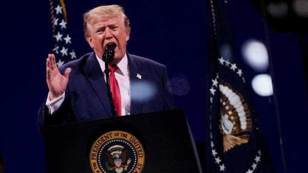 Donald Trump spricht vor einem Rednerpult mit dem Siegel des Präsidenten der Vereinigten Staaten vor US-Flaggen.