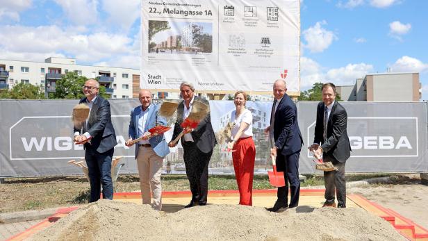 Elke Hanel-Torsch, Ernst Nevrivy und weitere Beteiligte werfen beim Spatenstich für den neuen Gemeindebau in der Melangasse 1A Erde in die Luft.