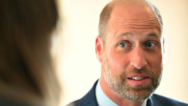 Prinz William blickt während eines Gesprächs aufmerksam zur Seite.