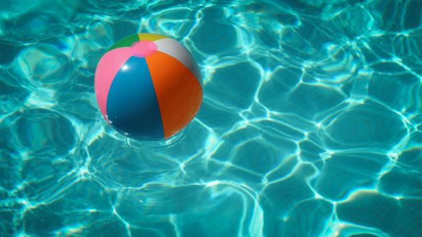 Bunter Strandball treibt auf der Wasseroberfläche eines Schwimmbeckens.